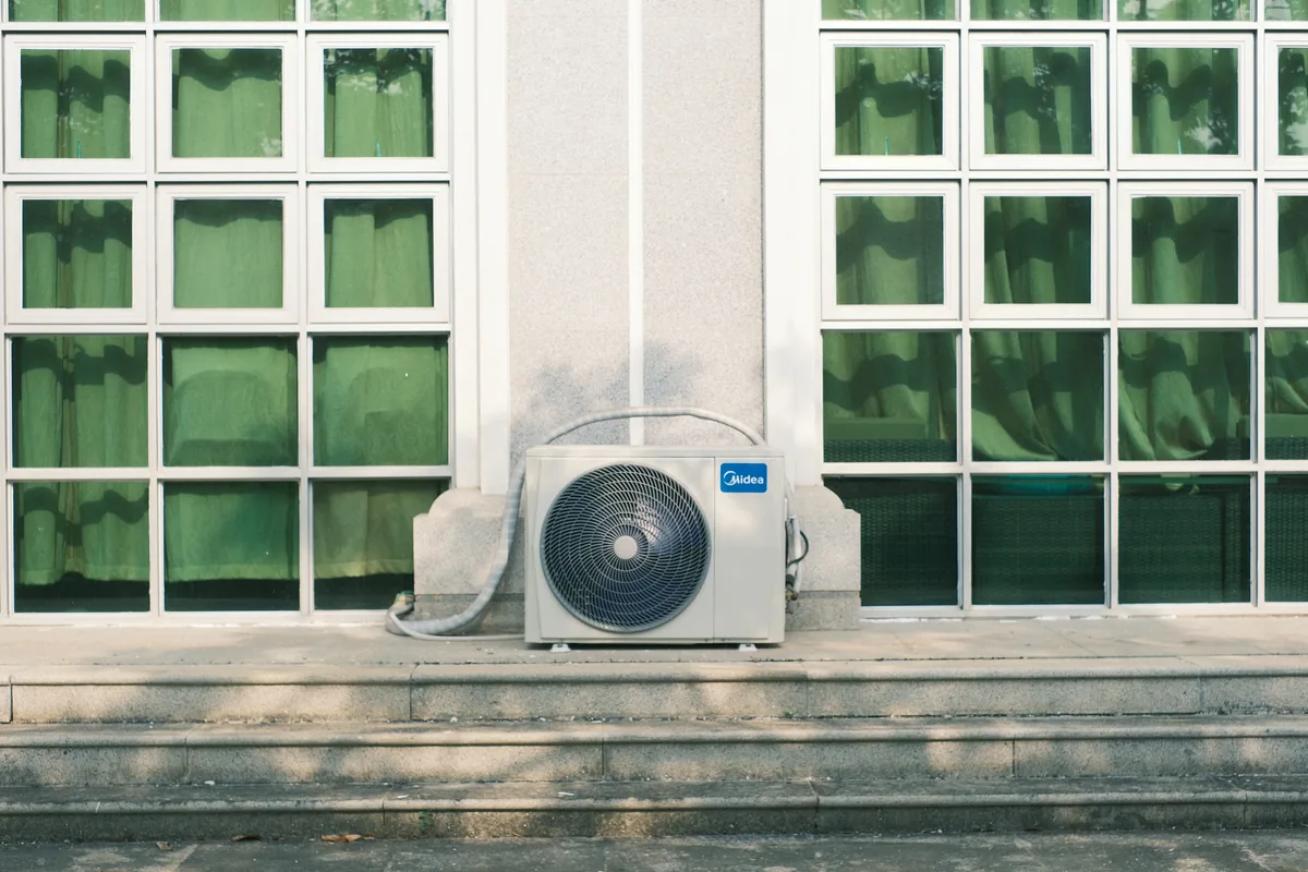 HVAC technician installing an outdoor cold-climate heat pump unit