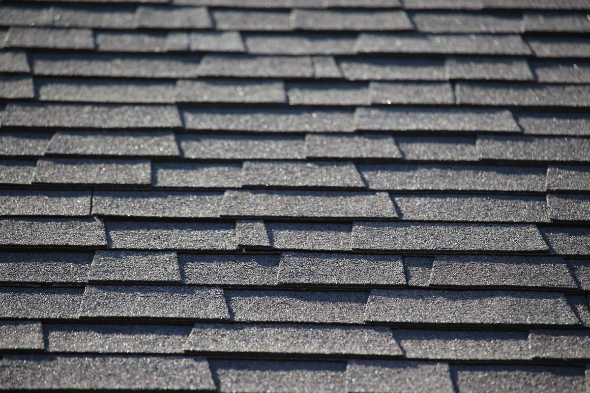 Roofer installing architectural shingles on a Massachusetts home
